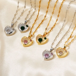 Minimalist heart-shaped copper pendants with colorful zircon inlay on silk background