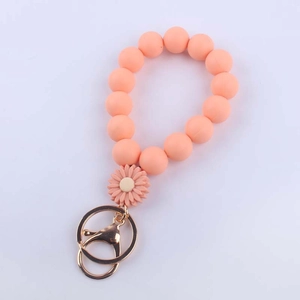 Detail of pink silicone daisy bead wristlet keychain with gold metal clasp