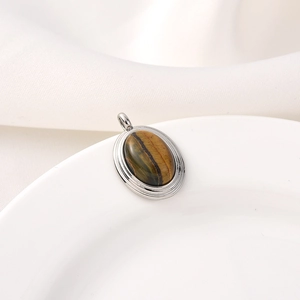 Elegant tiger eye stone pendant with silver metal bezel on white silk background
