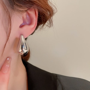 Polished silver teardrop earrings shown on model to demonstrate size and fit