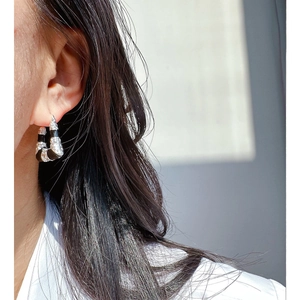 Close-up of black enamel bamboo earrings with silver metal and inlaid zircon stones