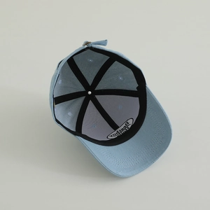 Detail view showing the reinforced seams and inner lining of the light blue denim cap