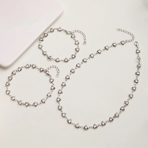 Detailed flat lay of silver heart-shaped gemstone necklace and bracelet set jewelry
