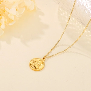 Detail of vintage gold round necklace with embossed mother and child pattern