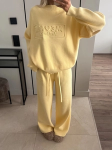 Yellow knit set featuring long sleeve crewneck sweater with MEWE embossing and wide leg pants