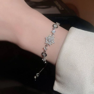 Close-up of snowflake pendant bracelet with zircon inlay and adjustable chain on wrist