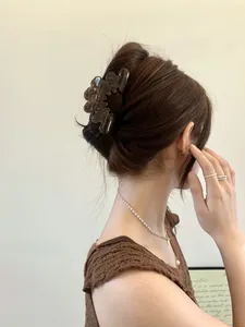 Close-up of a large brown acetate claw clip securing hair in a French twist hairstyle