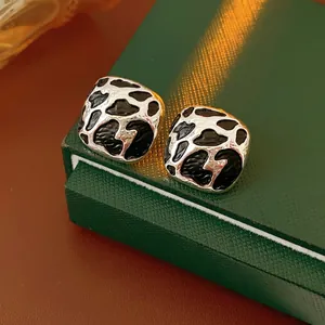 Retro square leopard print earrings in silver frames displayed on a green jewelry box
