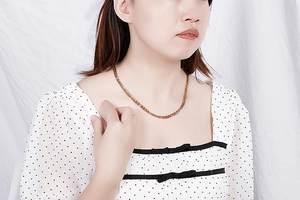 Close-up of minimalist gold-plated stainless steel chain necklace worn by a model