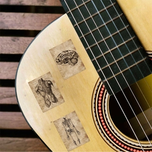 Retro anatomical stickers featuring brain and skeleton designs on a wooden guitar body