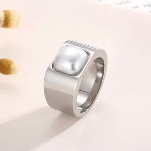 Dettaglio ravvicinato di un anello largo in argento con inserto quadrato in madreperla