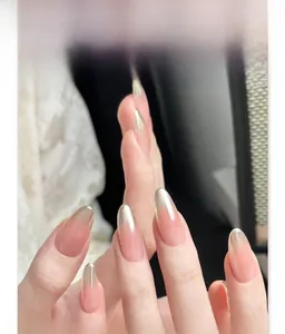 Macro detail of almond press-on nails featuring a nude base and silver chrome gradient tips
