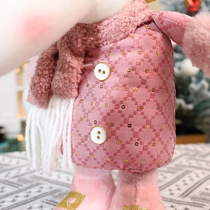 Close-up of pink sequined plush doll fabric texture and decorative button details