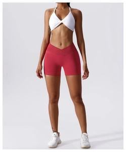 Detail der roten Yoga-Shorts mit V-Bund und weißem Halterneck-Sport-BH für Fitnessübungen
