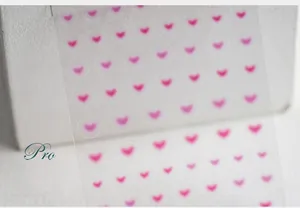 Macro detail of TS-500 professional pink gradient heart nail art stickers on clear film