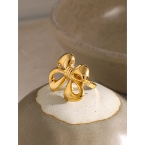 Elegant 18k gold plated stainless steel bow ring on a rustic ceramic plate