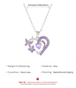 Détail du pendentif en forme de cœur avec pierres violettes et gravure I Love You