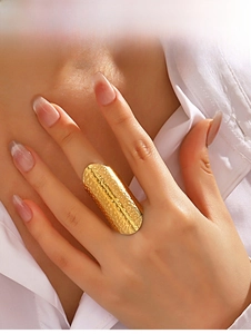 Detailed view of long gold hammered stainless steel wide ring worn on the finger