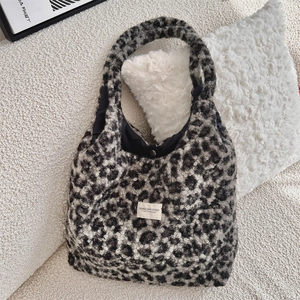 Macro detail of leopard faux fur tote bag showing metal magnetic snap closure and texture