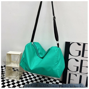 Dettaglio borsa da viaggio in nylon verde menta con tracolla e texture impermeabile
