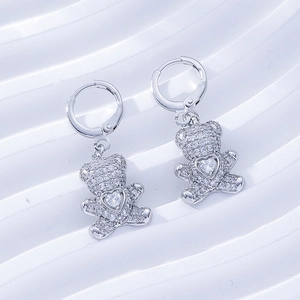 Detailed macro of silver bear drop earrings with heart zircon inlay and latch back design