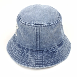 Détail du chapeau bob en denim bleu avec nœud en perles blanches et coutures parallèles
