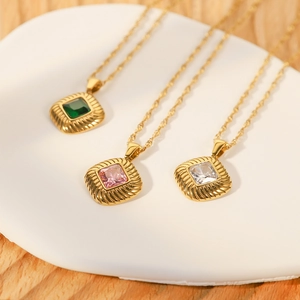 Detail of square zircon pendants in green, pink, and white on gold titanium steel chains