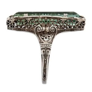 Vue détaillée des motifs évidés vintage et du zircon vert sur la bague oxydée