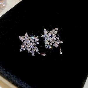 Gros plan de boucles d'oreilles en étoile avec zircon central sur velours noir