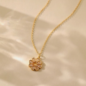 Elegante 18K vergoldete Blumen-Halskette mit Zirkonia-Steinen auf warmem Hintergrund