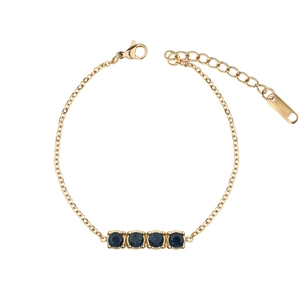 Detailed view of a gold chain bracelet featuring four round dark blue gemstones and a clasp