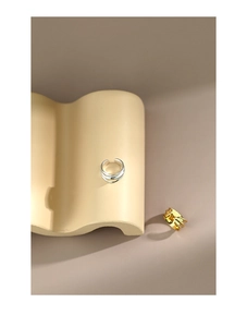 Detailed view of wide irregular silver and gold ear cuffs with multi-layer line design