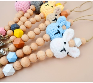 Detail of baby pacifier clip with crochet rabbit head and natural beech wood beads