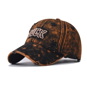 Vintage acid wash baseball cap in orange and black with LUCK embroidery and distressed holes