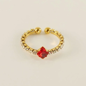 Detailed macro view of an 18k gold-plated ring with a square red gem and small zircons