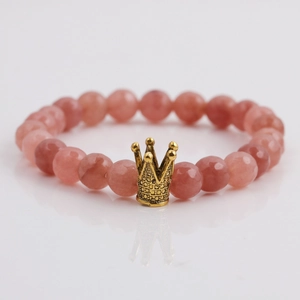 Makroansicht der 8mm rosa Erdbeerkristall-Perlenkette mit goldenem Kronen-Anhänger