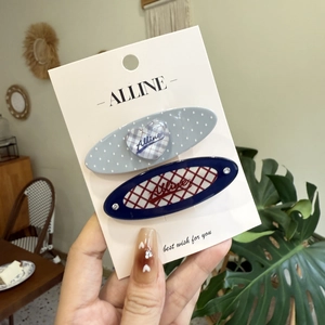 Nahaufnahme von blauen Polka-Dot- und Karo-Haarspangen auf einer Alline-Präsentationskarte