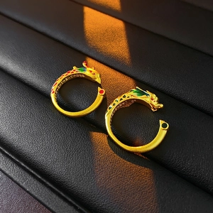 Close-up of golden dragon and phoenix rings with vibrant colorful enamel detailing