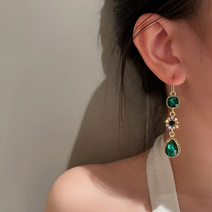 Vintage green rhinestone flower drop earrings with gold finish on model for stylish look
