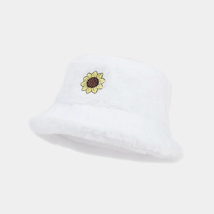 Detailed close-up of a white plush bucket hat with a yellow sunflower embroidery