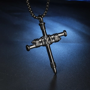 Détail d'un pendentif croix en acier inoxydable noir style punk fait de clous