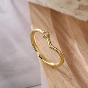 Minimalist 18K gold plated copper ring with zircon on a wooden base for women