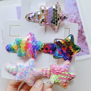 Close-up of five colorful star-shaped sequin hair clips on a white display card