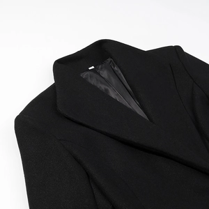 Gros plan du revers et de l'épaule d'un manteau en laine noir cintré et élégant