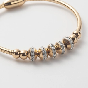Elegant gold titanium steel bracelet featuring zircon-studded beads and a polished finish