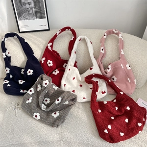 Vista piatta di borse tote colorate in peluche con motivi floreali autunnali