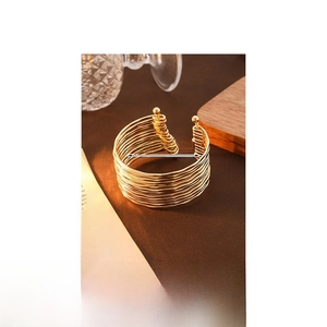 Detailed close-up of a layered gold ripple cuff bracelet with size and weight dimensions