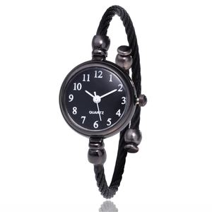 Detail of a vintage quartz bangle watch with black wire strap and round numeral dial