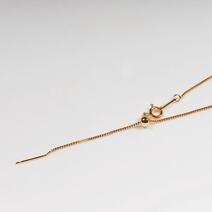 Adjustable golden fine chain necklace with slider bead mechanism on white background