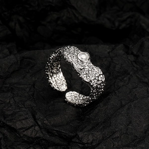 Irregular texture vintage open ring with a round gemstone on black paper backdrop